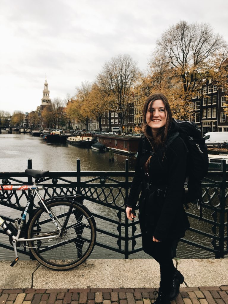 A young lady on a bridge in Europe with a bicycle from a blog post about How the Minimalist Mindset Changed My Life by Chelsey Home